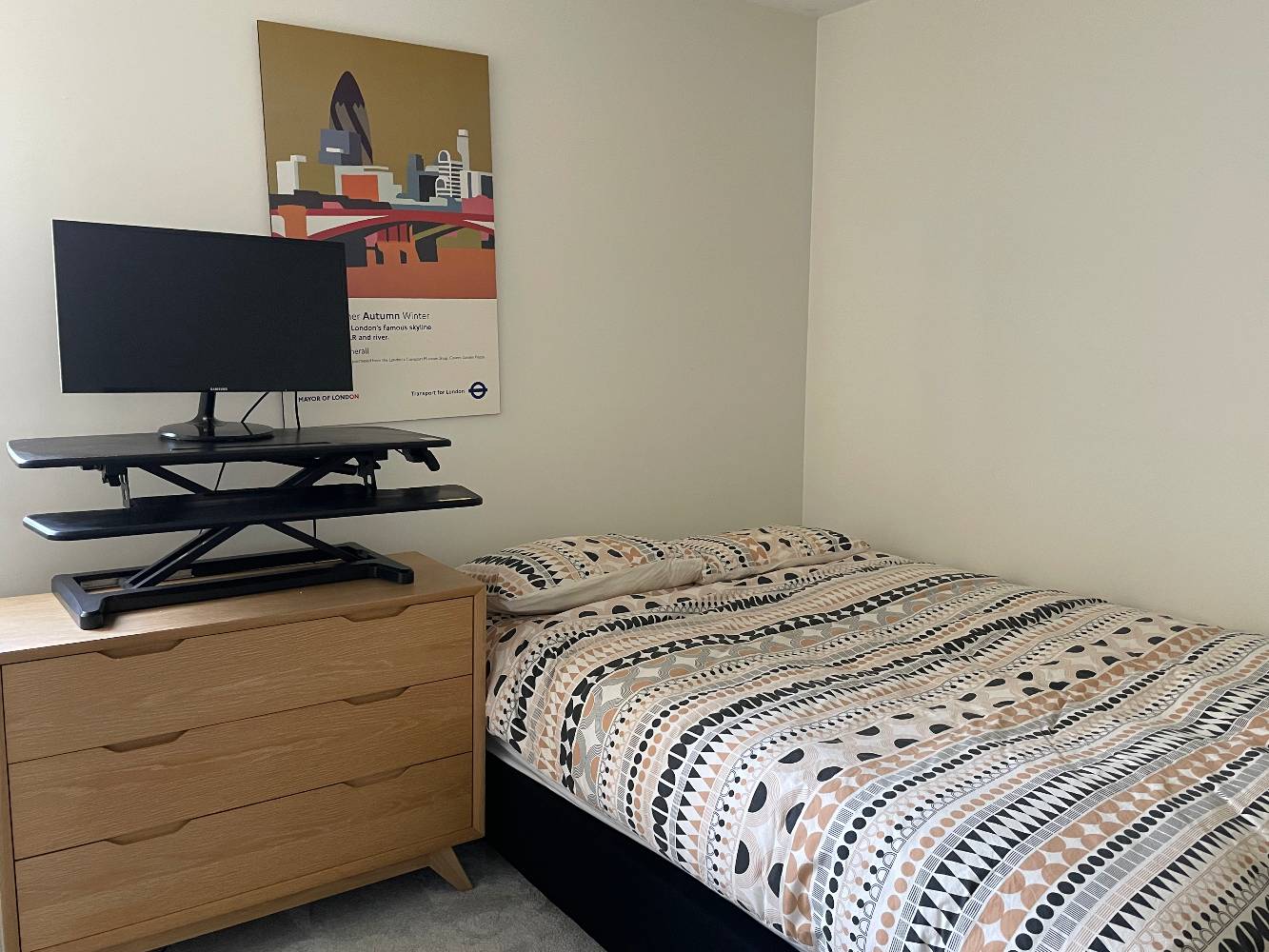 Spare bedroom with queen side bed and standing desk